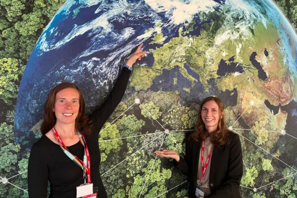 Digital Infrastructure and England's Connected Heartland team members in the Environment room, pointing to a wall mural of the earth