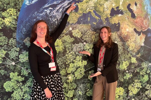 Digital Infrastructure and England's Connected Heartland team members in the Environment room, pointing to a wall mural of the earth